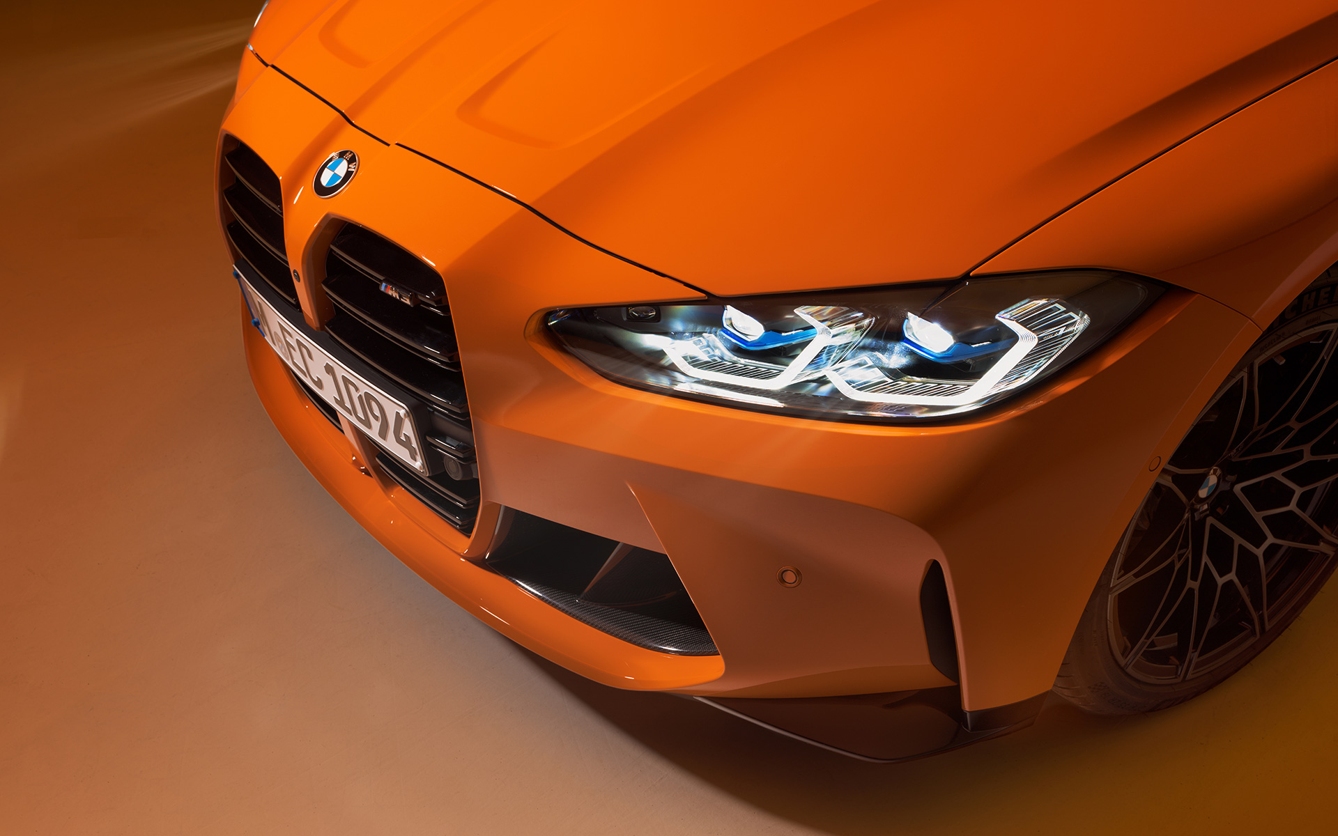 BMW M4 Competition Coupé, G82, 2021, BMW Individual Fire Orange krāsa, stāvošs automobilis, trīs ceturtdaļu priekšpuses skats, tuvplāns ar skatu no augšas